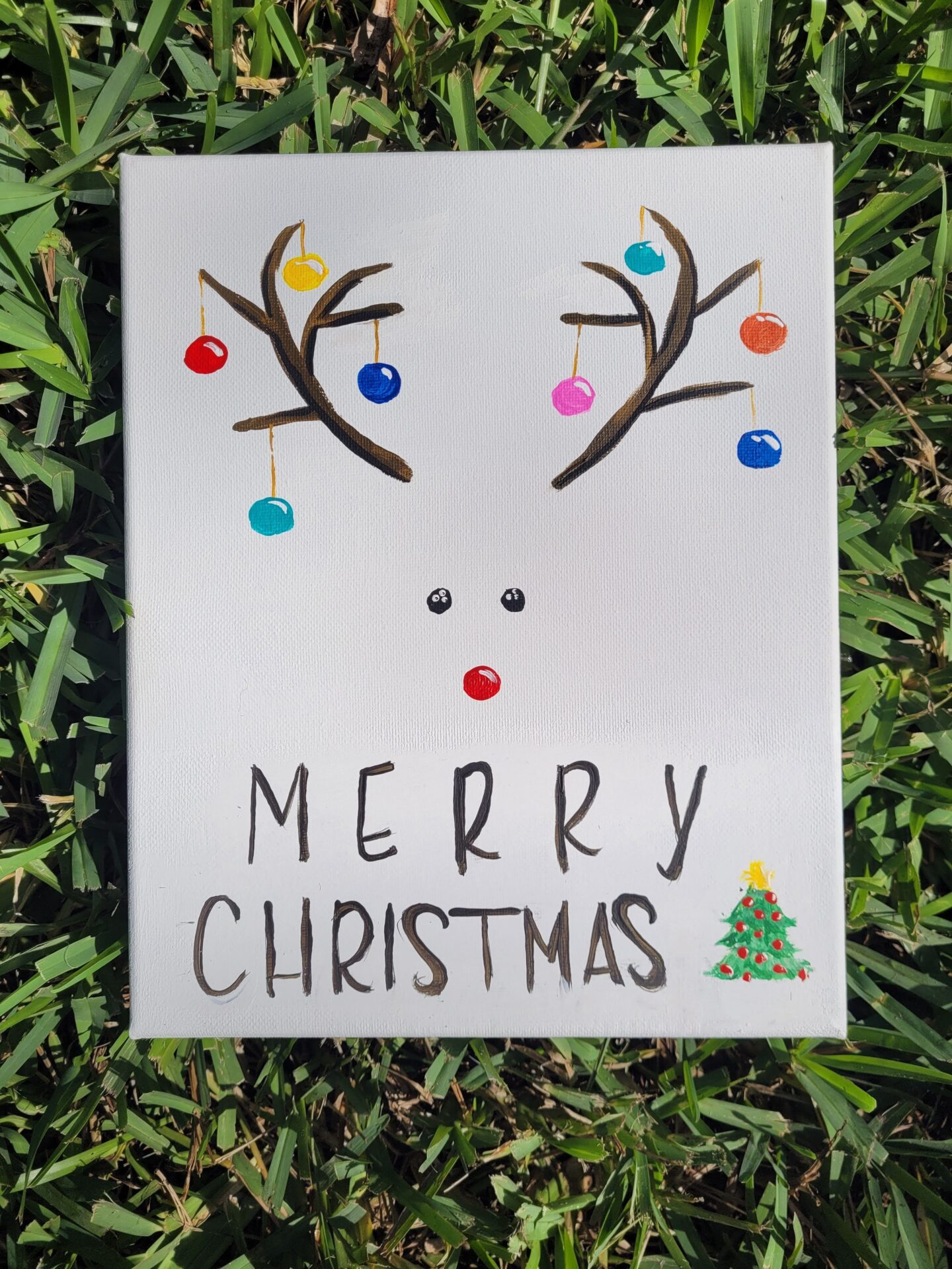 A Christmas Themed Painting Canvas on Grass